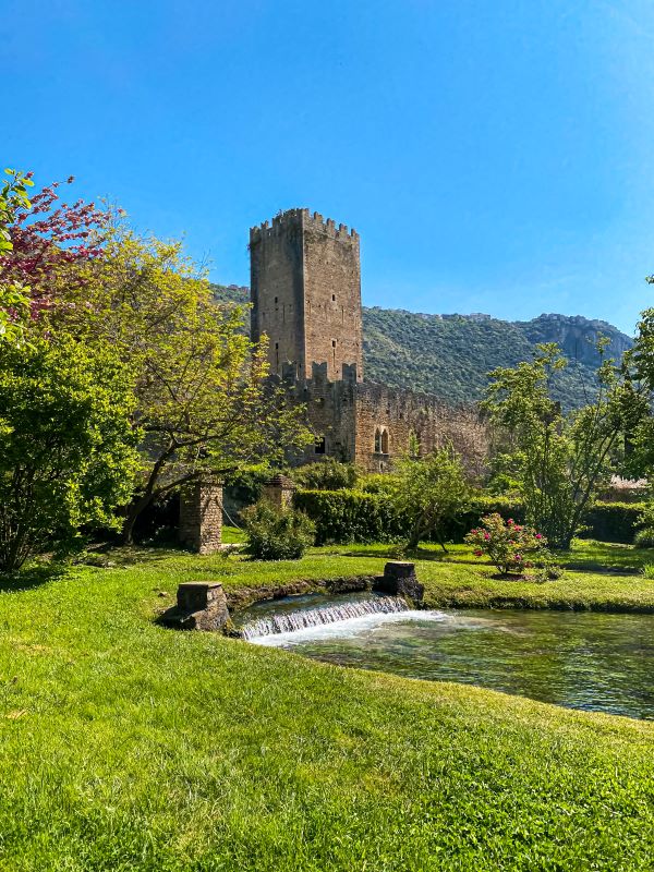 Giardino di Ninfa giochi d'acqua e la torre del castello sullo sfondo